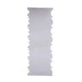 Stainless steel cake decorating scraper with a patterned polygon edge on a kitchen worktop.