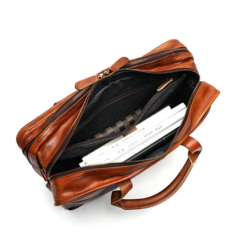 Brown vintage leather men's briefcase showing internal organiser pockets for laptop, documents, and phone.