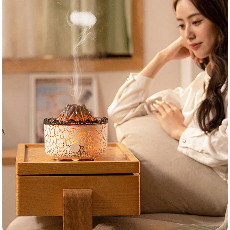 Column-shaped volcano humidifier diffuser emitting mist with red and orange LED flame effect