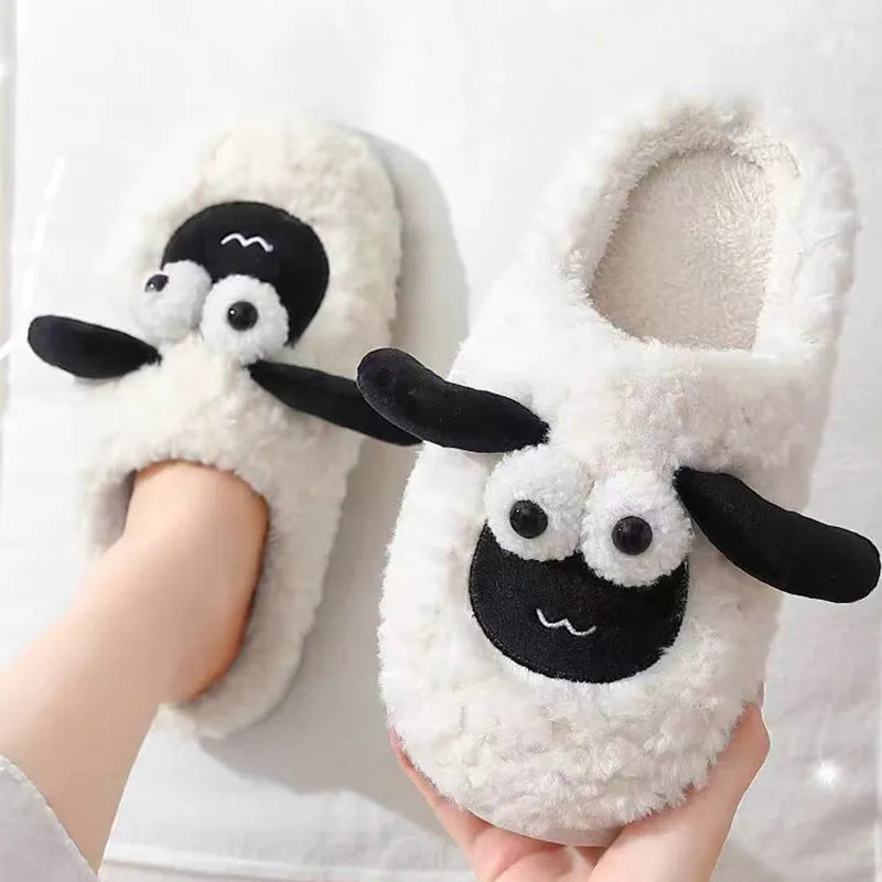 Brown suede slip-on slippers with a PVC sole on a wooden floor.