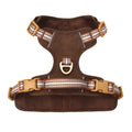 Brown leather dog harness with reflective strips showing buckle closure and adjustable chest strap
