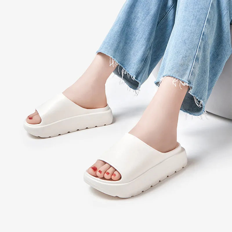 Women's beige fish mouth slippers with a thick EVA sole on a bathroom tile floor.