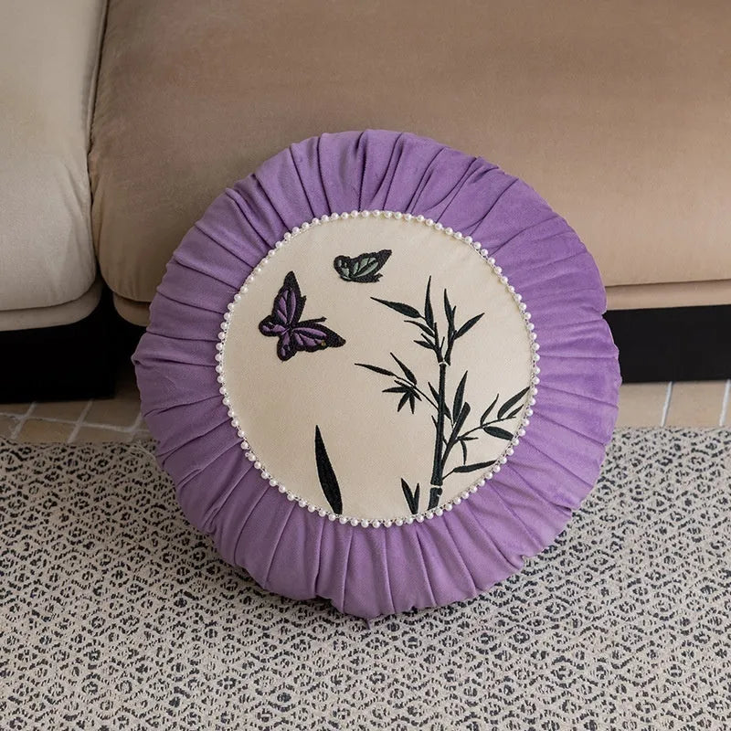 Square decorative cushion with Chinese-style butterfly embroidery in beige, black, and purple colours.