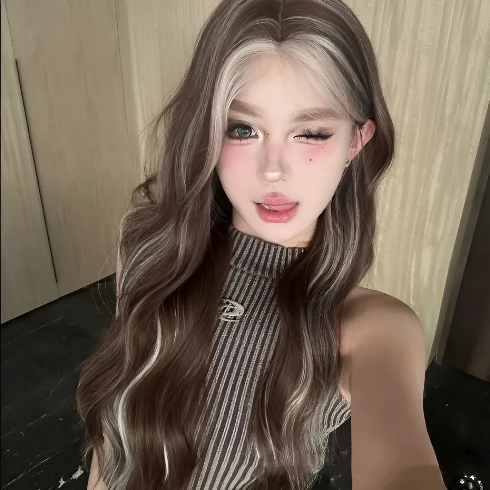 Lace front wig with long curly grey gold highlighted synthetic hair on display