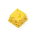 Yellow solid resin artisan key cap sculpted like a piece of cheese for mechanical keyboards.