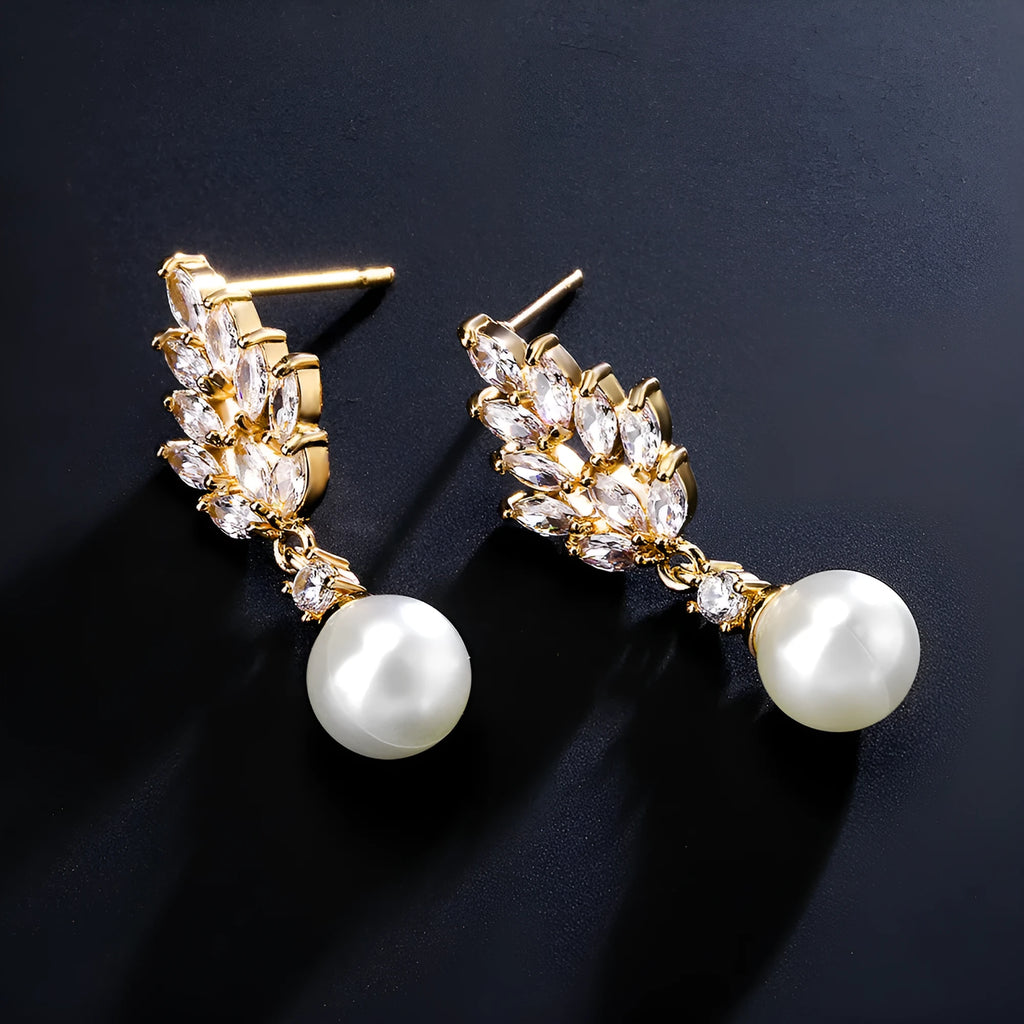 Geometric flower-shaped earrings with micro inlaid zircon and pearl details on a gold-toned metal base.