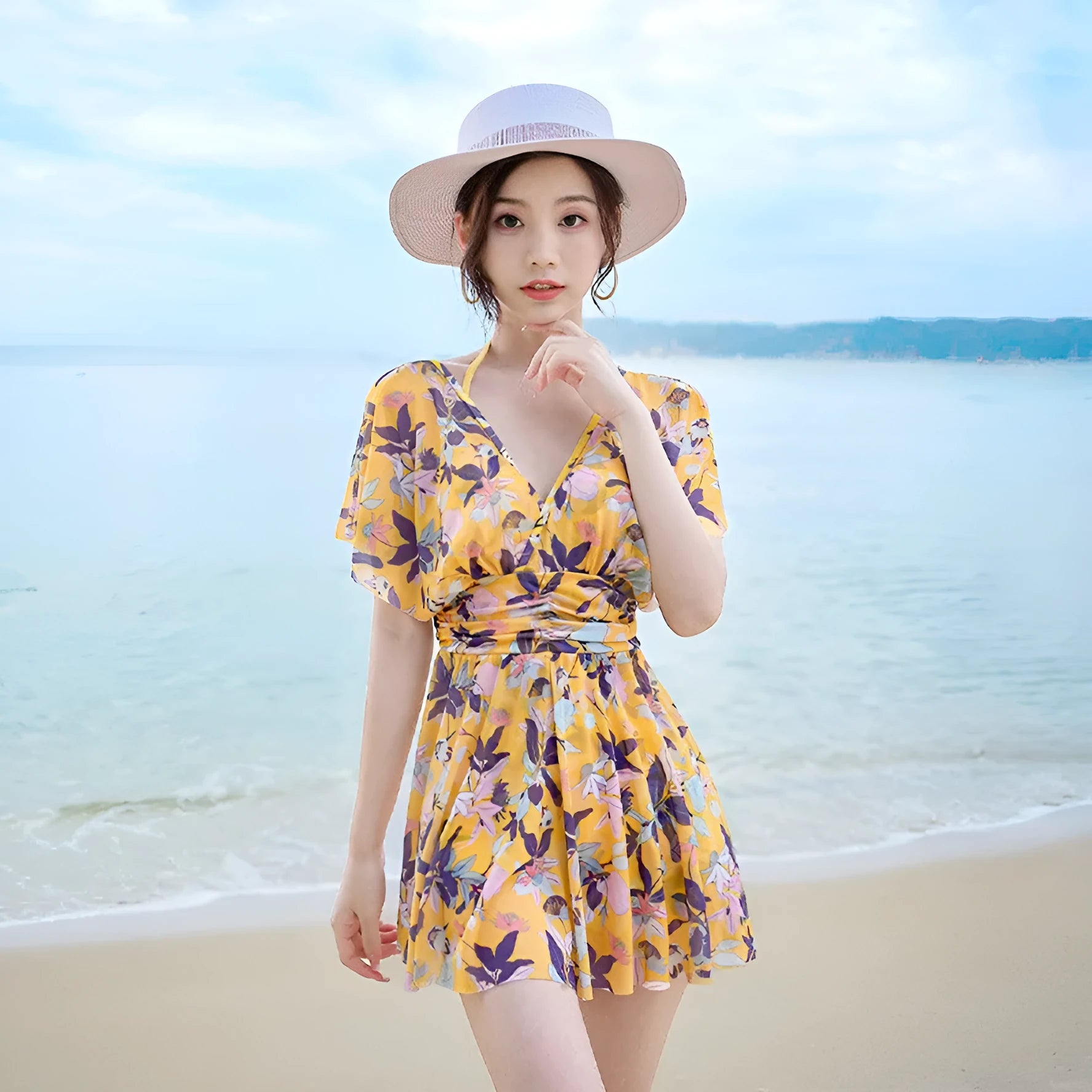 Yellow floral print women's one-piece swimsuit with skirted design on mannequin.
