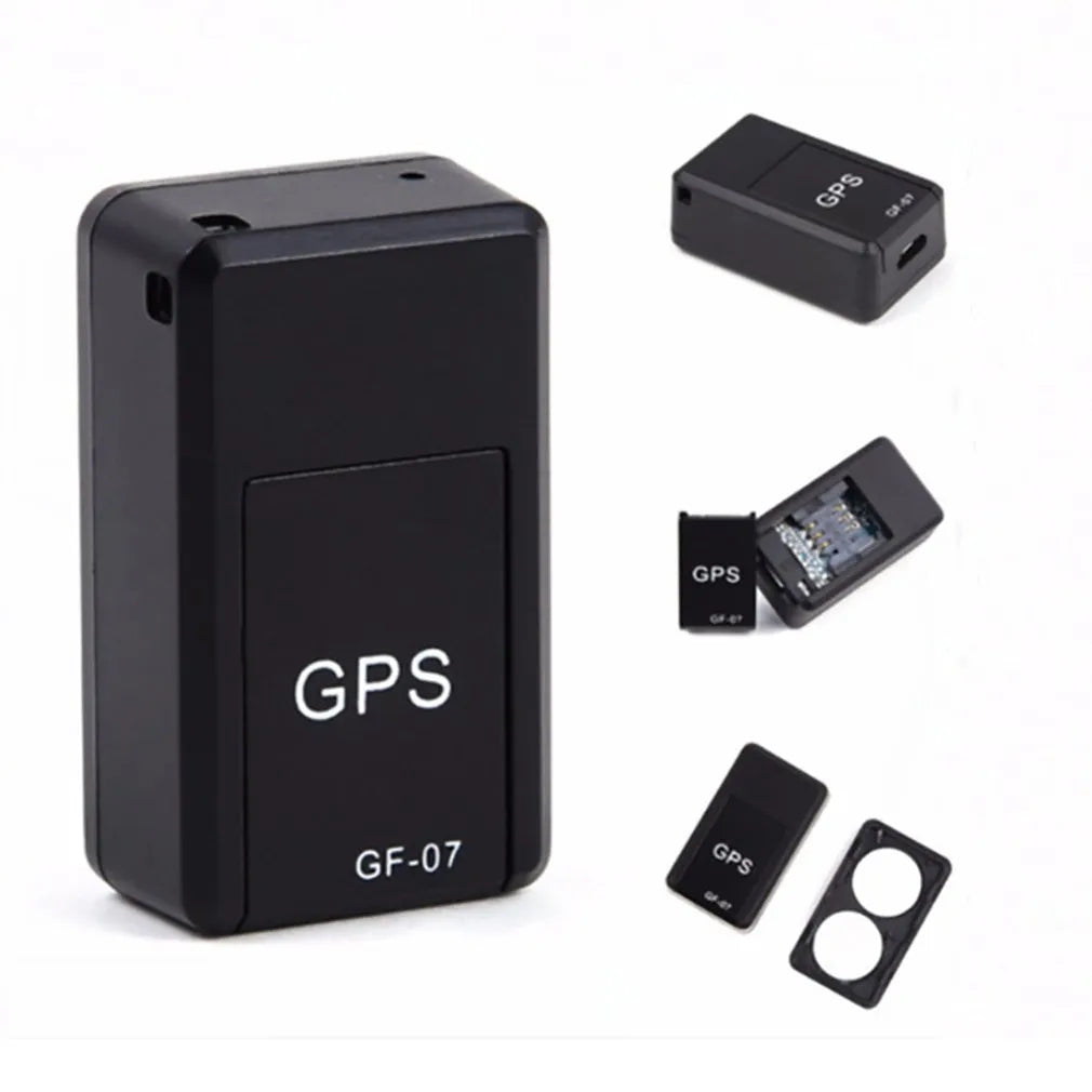 Small black magnetic GPS car tracker with USB charging cable on a metal surface.