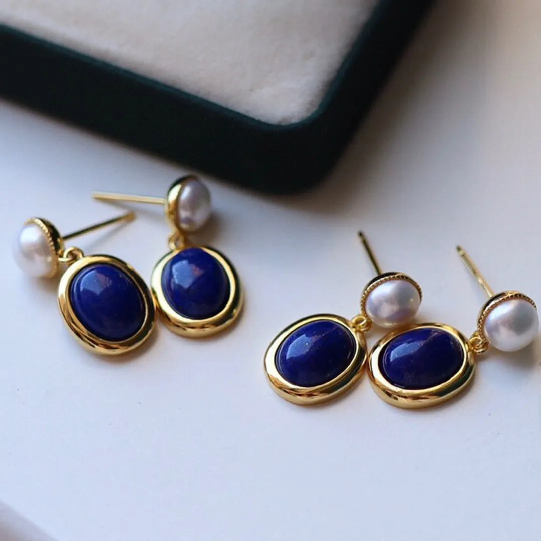A pair of simple stud earrings with blue lapis lazuli pearls set in silver backs.