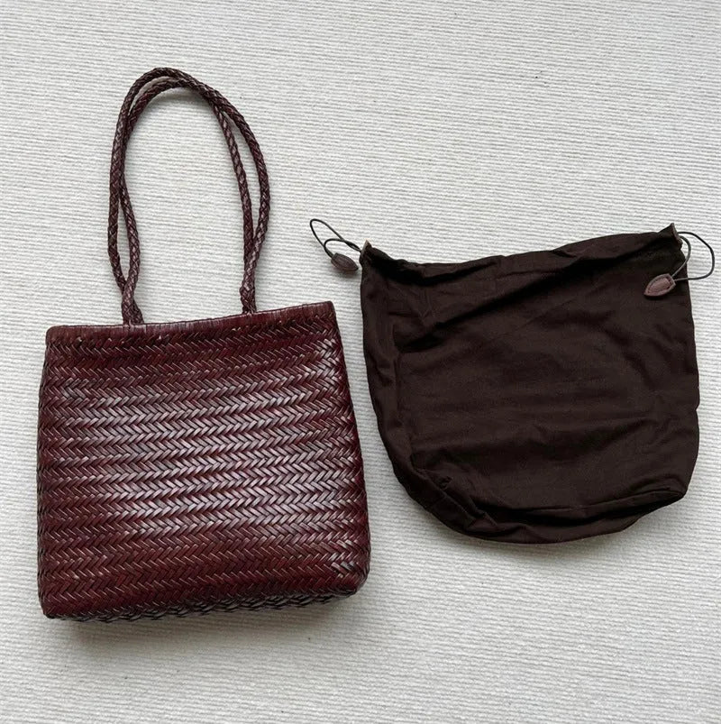 Brown handmade woven leather tote bag with a three-dimensional front pocket and shoulder strap.
