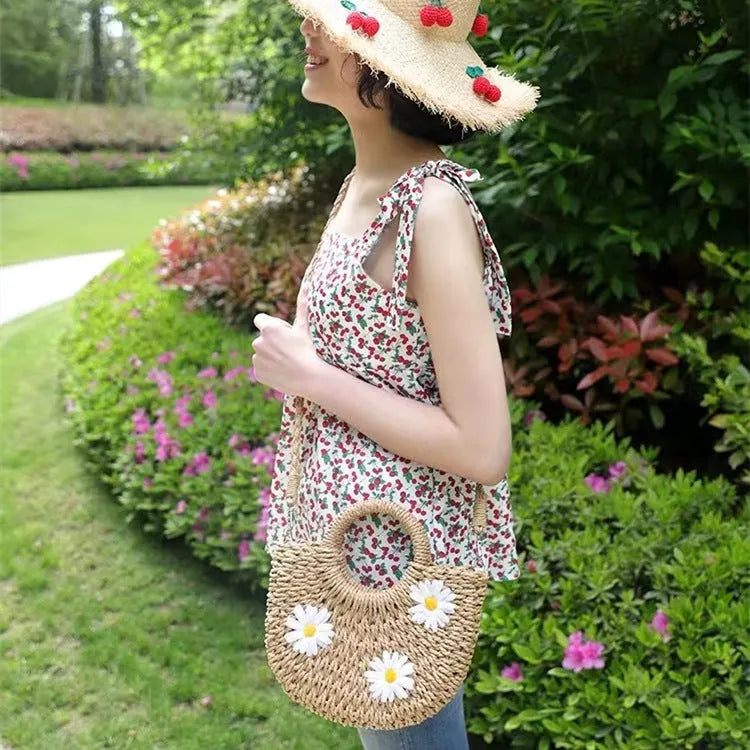 Light brown woven straw women's crossbody bag with a daisy pattern design.