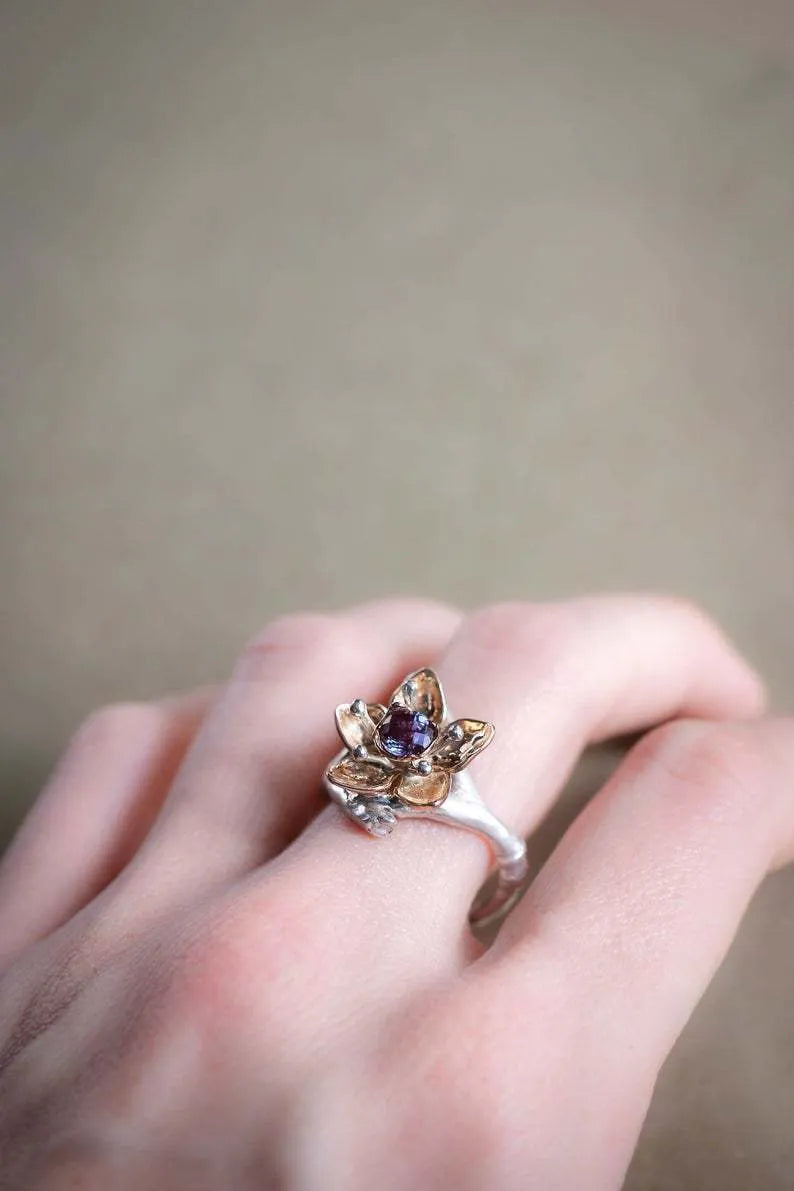 Silver two-tone alloy ring with a geometric floral pattern on a model's hand.