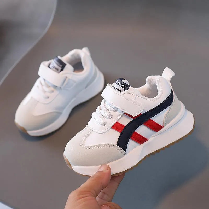 Children's white casual sneaker with Velcro strap, synthetic leather upper, and rubber sole on a neutral background.