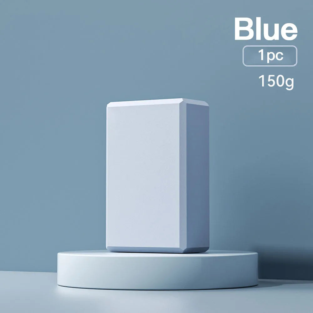 Solid blue EVA foam yoga brick with ridged hexagonal surface, shown next to a pink block.