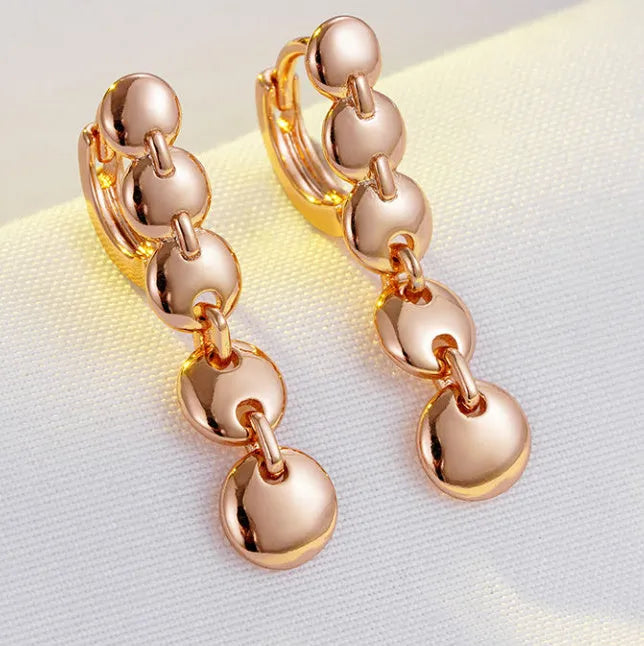 A pair of gold-coloured retro long round circle earrings with a woven copper design.