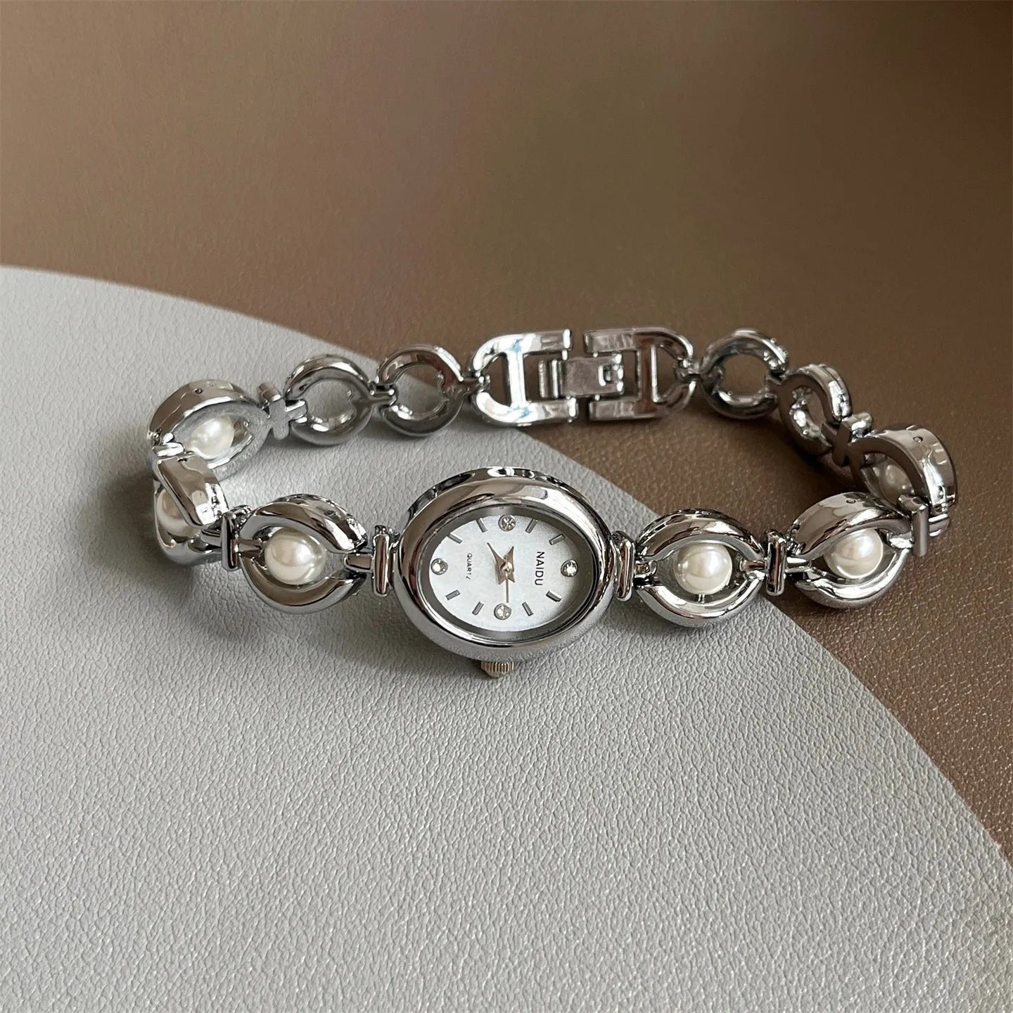 Women's quartz fashion bracelet watch with alloy case and pointer display, gold strap with white surface