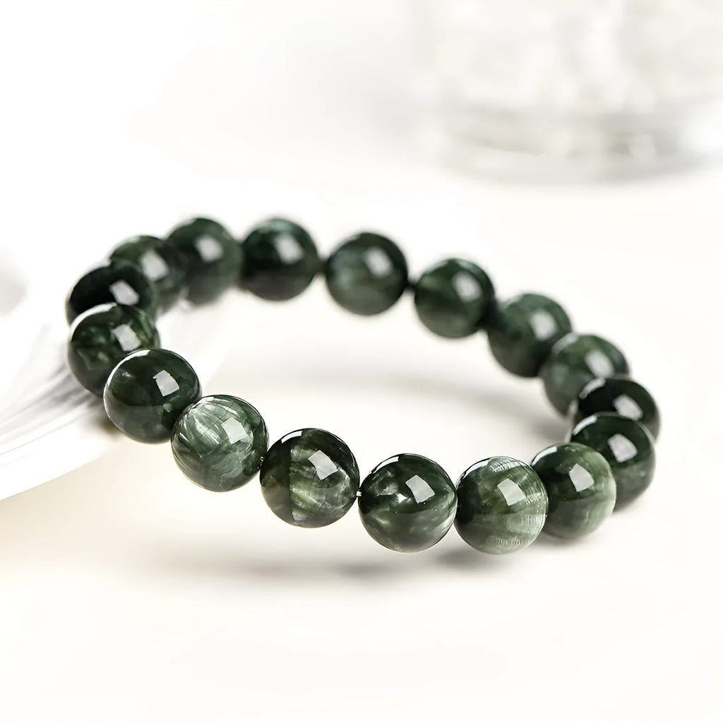 Natural green dragon crystal bead bracelet with geometric ruyi pattern on white background.