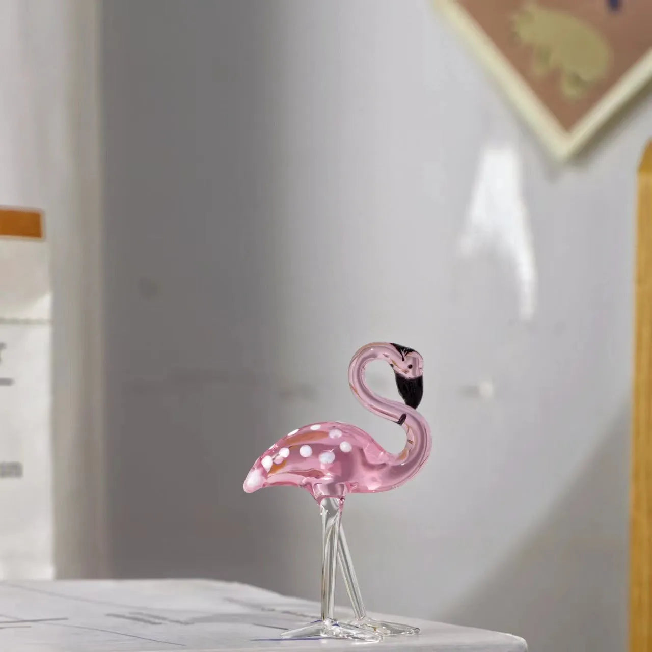 Pink crystal flamingo decorative ornament on a table for modern home decor.
