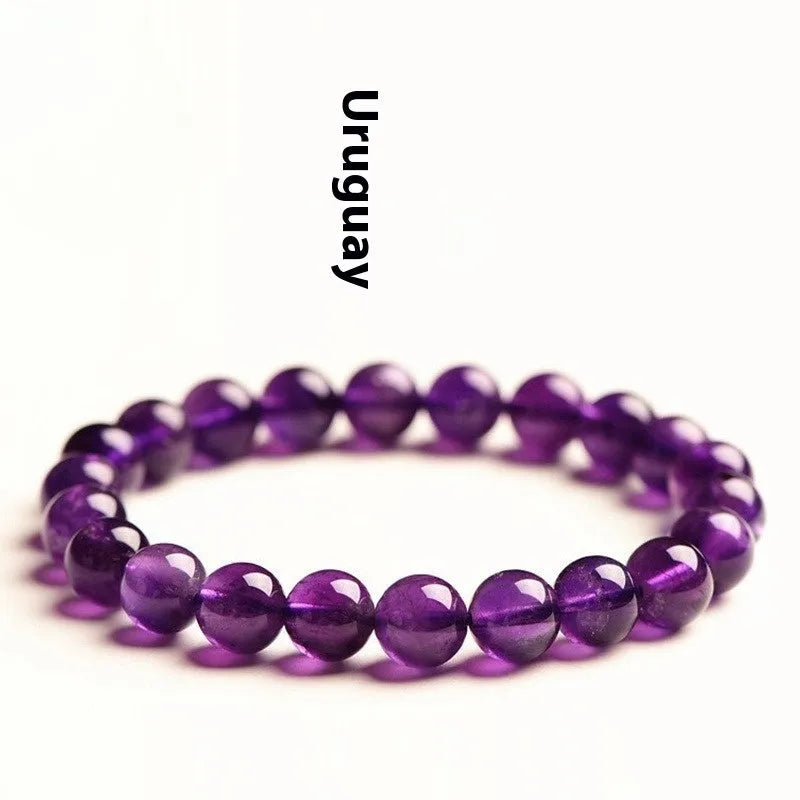 Close-up of a polished natural amethyst bead bracelet with a sliding knot closure on a wrist.