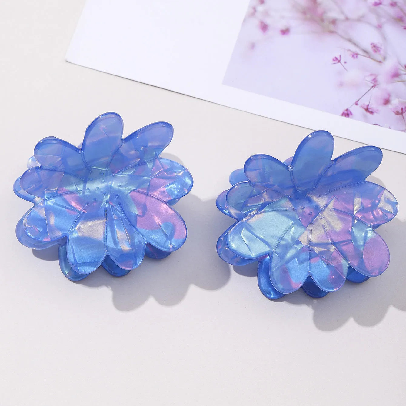 Dazzling blue PVC flower hair clip with glossy finish, 6cm length, on a light background