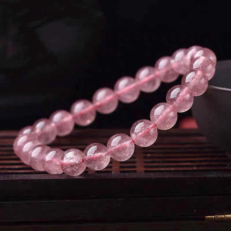 Polished strawberry quartz crystal bracelet for women, shown in three bead size options: 6mm, 8mm, and 10mm.