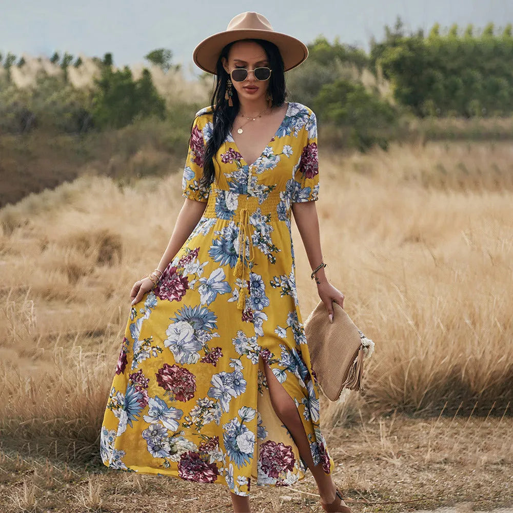 Yellow floral print dress on a hanger showing V-neck, short sleeves, elastic high waist, and full mid-length skirt.