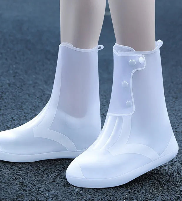 White high-top PVC reusable shoe covers for women, shown on feet.
