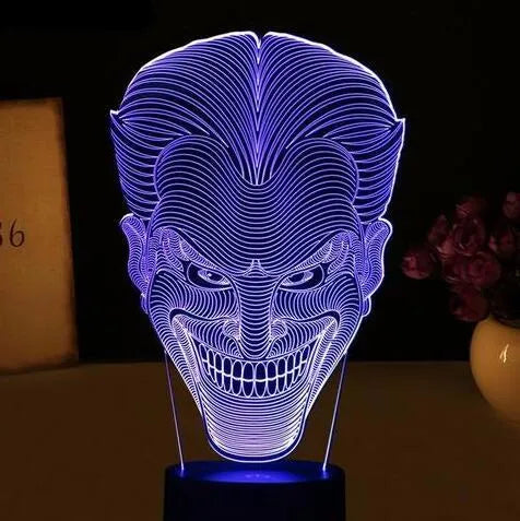 A 3D acrylic LED desk lamp showing multicolour gradient lighting, sitting on its square base with a USB cable.