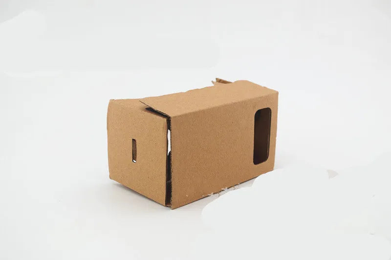 Pink and white flat-pack cardboard VR glasses viewer for smartphones with 3D lenses and straps.