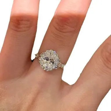 Close-up of a silver geometric ring with a large elliptical diamond on an adjustable open band.