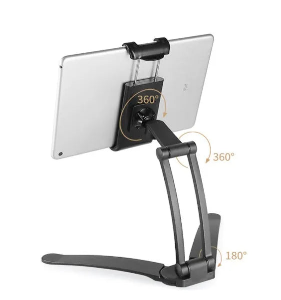 Silver aluminium alloy tablet stand with adjustable black clips holding a tablet, showing 360-degree rotation on a wooden desk.