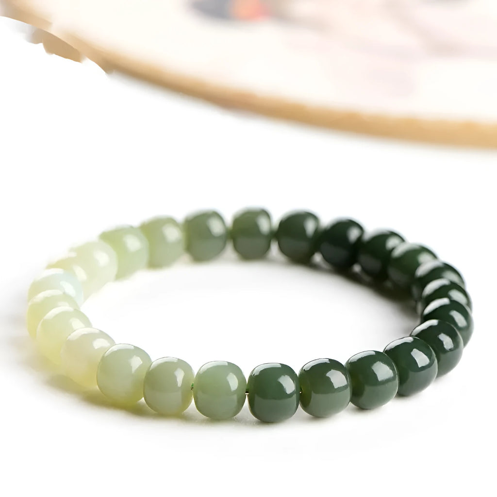 Natural Hetian jade bracelet with gradient clear water colour on a wrist.