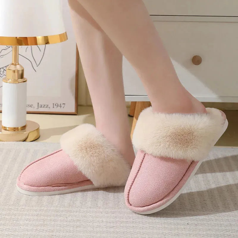 Women's brown plush indoor slippers with a round toe, flat heel, and stitching detail.