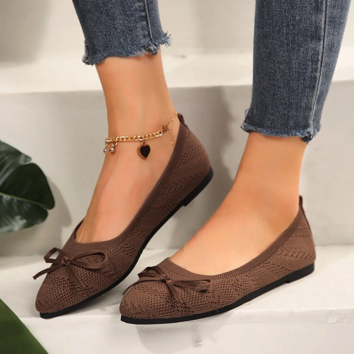 Women's blue knitted flat loafers with a pointed toe and a decorative bow on the front