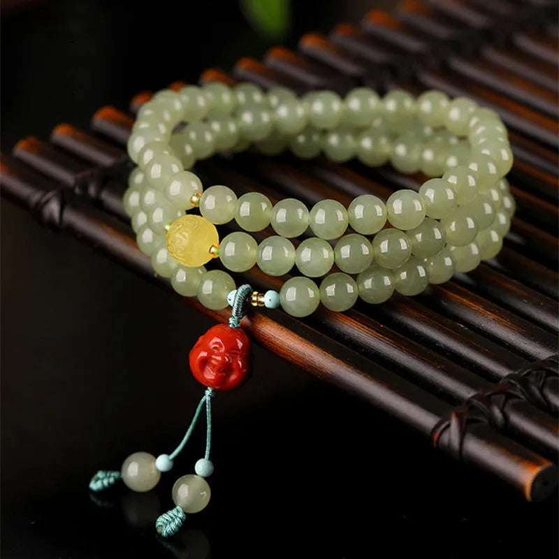 Pale blue Hetian jade bracelet with three circle design and 6mm beads on a wrist.