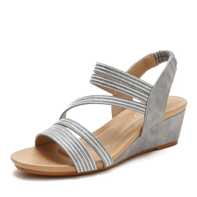 Women's gold leather platform sandals with a mid-heel on a white background.