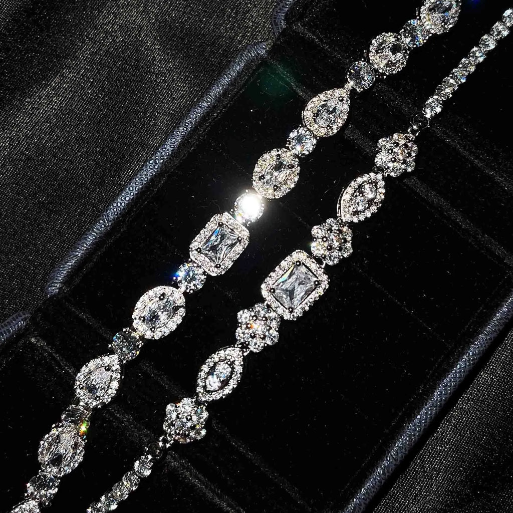 Close-up of a women's geometric silver bracelet with inlaid zircon stones on a wrist, showing adjustable chain.
