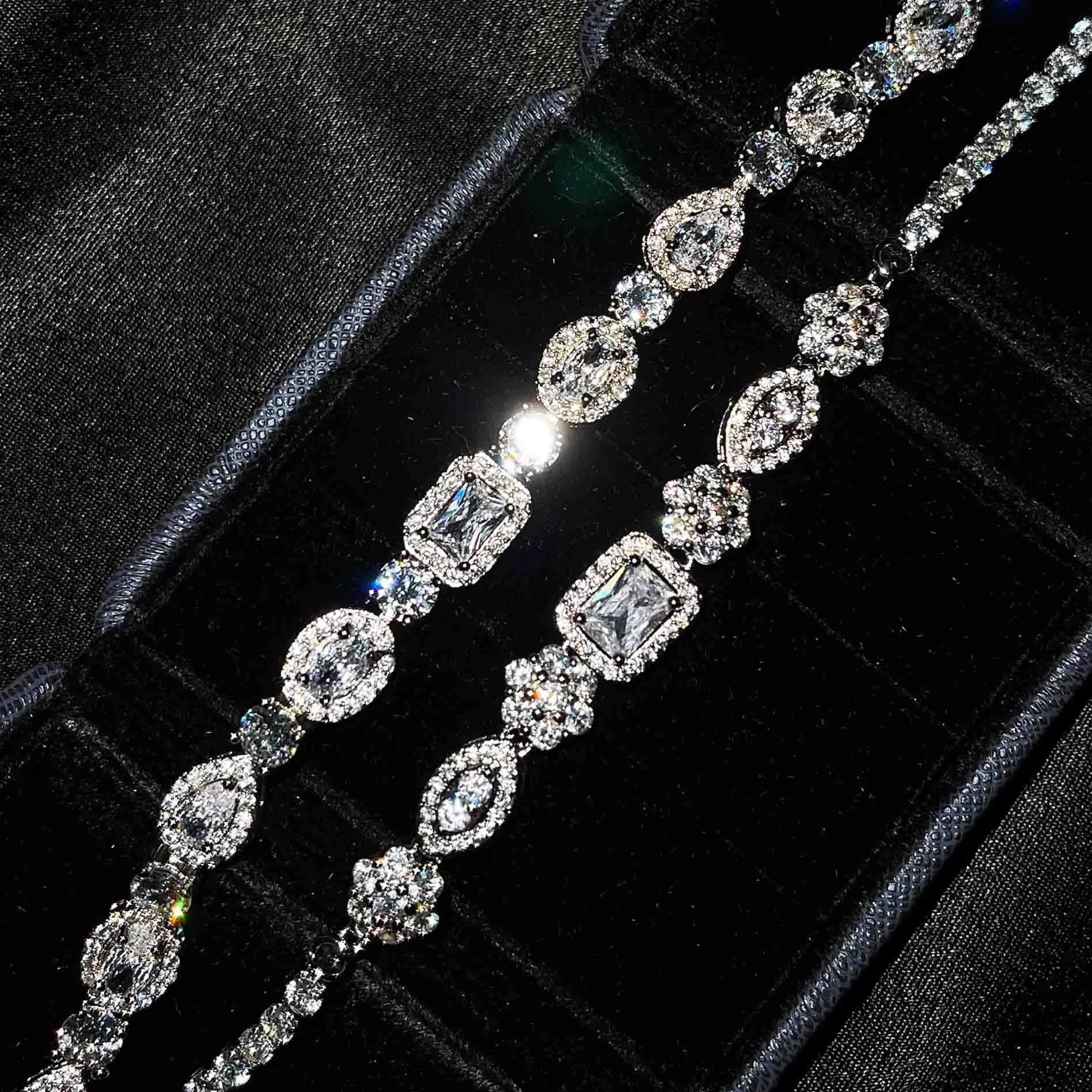 Close-up of a women's geometric silver bracelet with inlaid zircon stones on a wrist, showing adjustable chain.