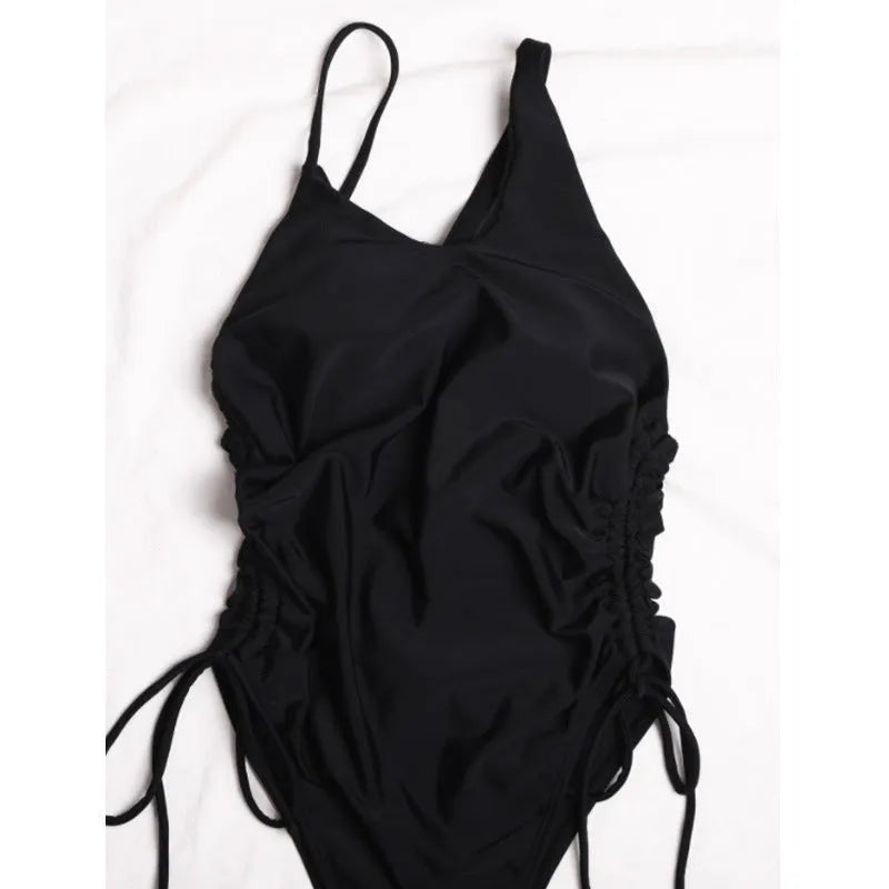 Black tight-fitting sleeveless women's dress with lacing detail and sloping shoulders.