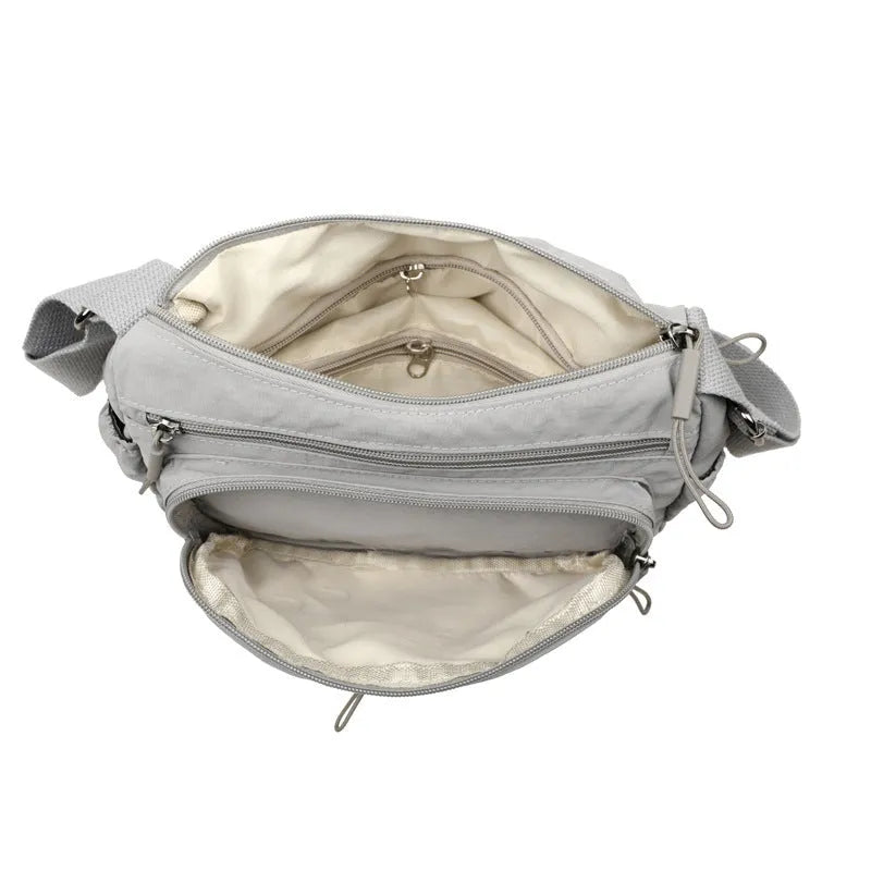 Soft water-repellent nylon crossbody bag showing three-dimensional pocket and adjustable shoulder strap