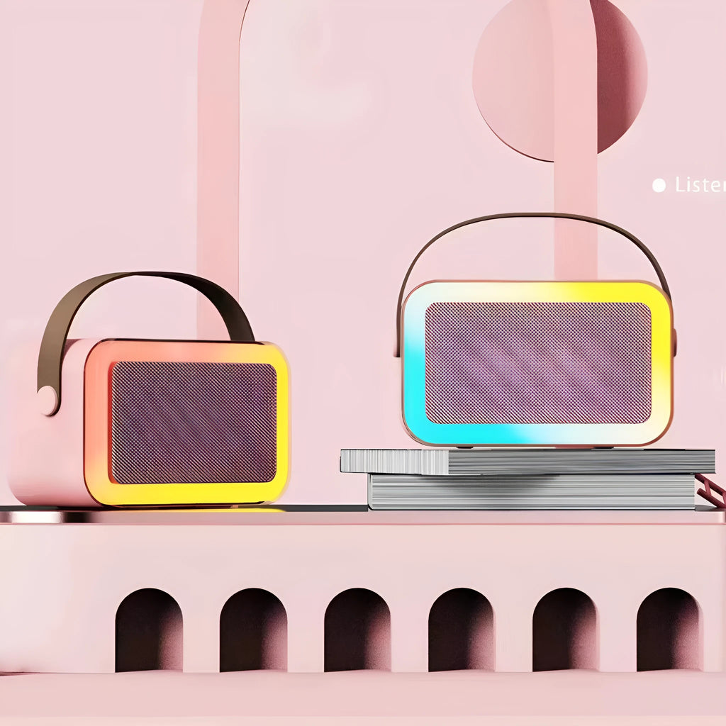 Pink Bluetooth speaker and microphone combo with coloured LED lights illuminated, placed on a table.