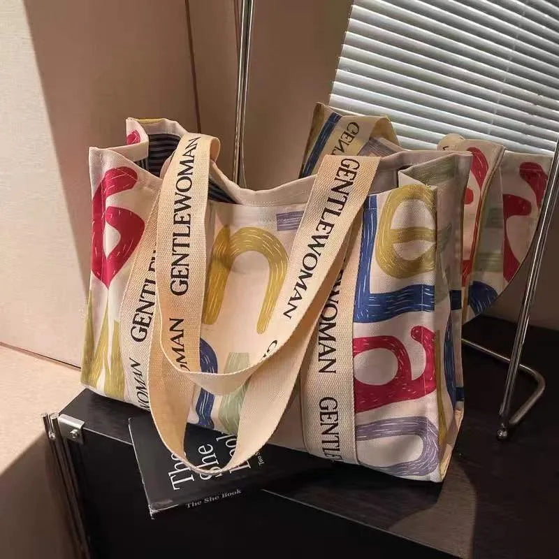 Canvas women's travel tote bag with printed design options including black letters, coloured letters, and pattern styles