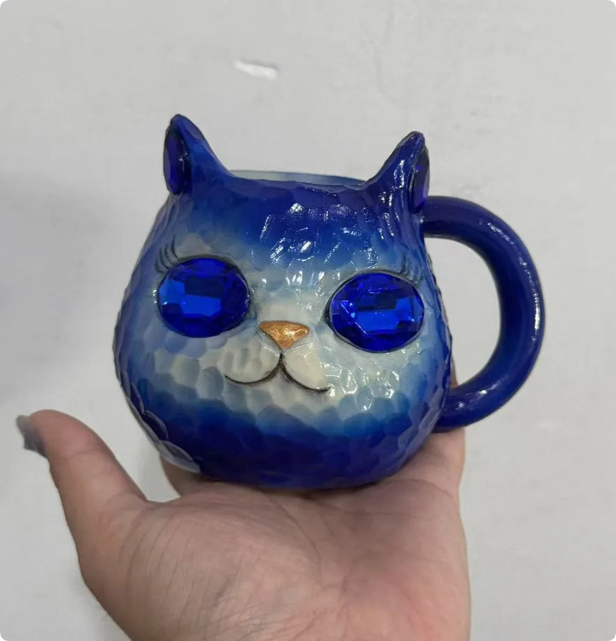 Resin cat cup ornament with crystal earth design in blue, green, pink, or purple colour options.