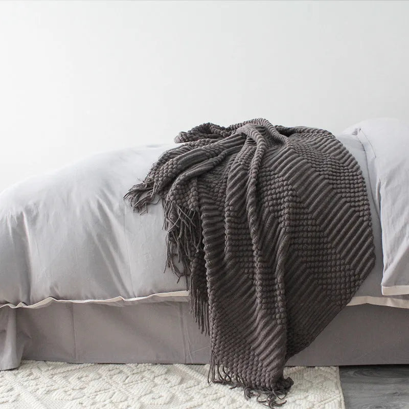 Small light grey polyester nap blanket laid flat showing its size.