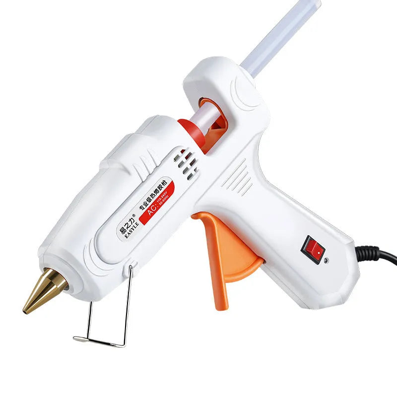 White electric hot melt glue gun with metal stand and anti-heat blanket on a work surface