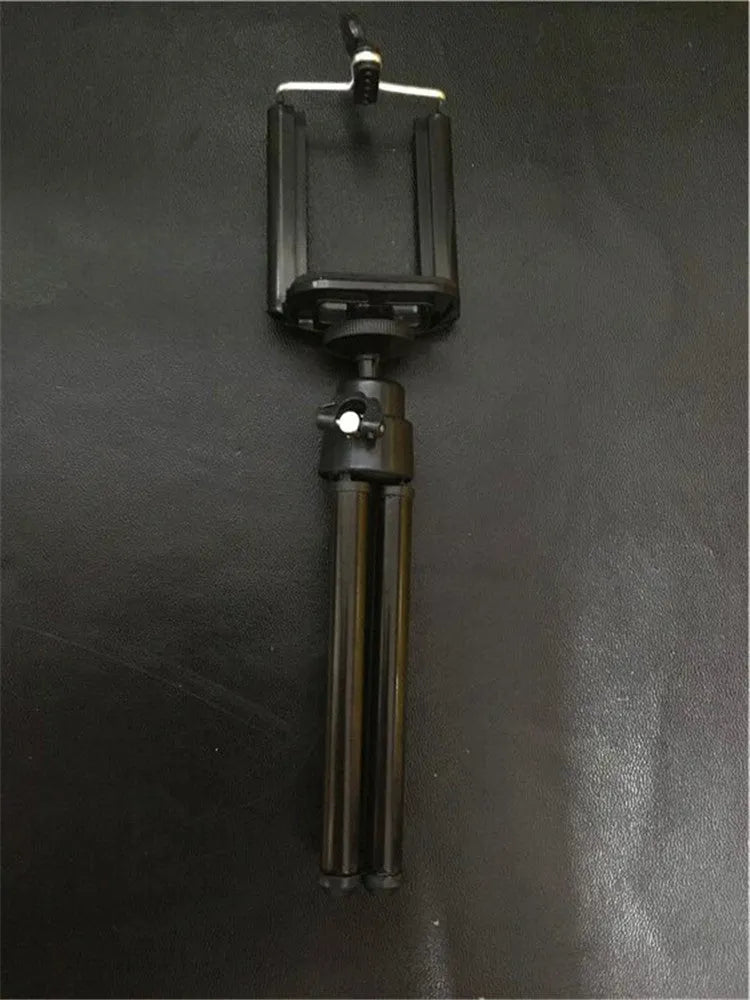 Black adjustable desktop phone holder with two-section metal bracket on a wooden desk
