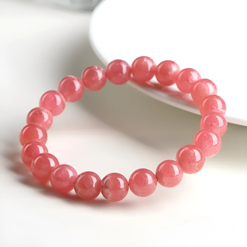 Women's geometric red rhodochrosite crystal bracelet with a longevity lock on a white background.