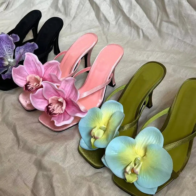 Pink satin women's high heel sandals with a square toe and a white artificial flower decoration.