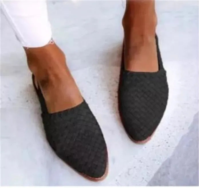 Women's black pointed toe flat sandals with a silver buckle fastening on the instep.