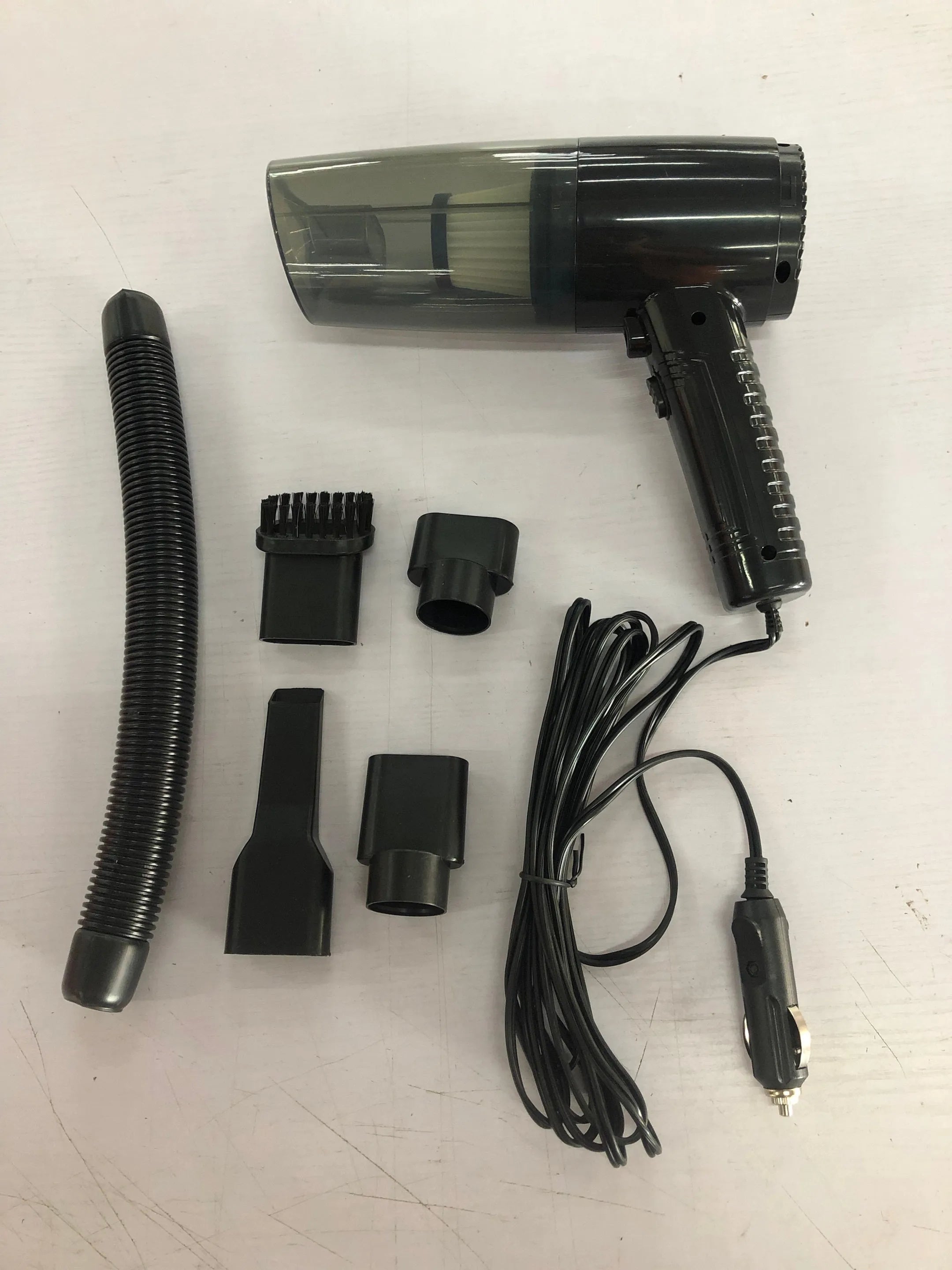 Starry Sky Black portable car vacuum cleaner with long cord and set of five suction head accessories on a grey background.